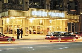 A car parked in front of a building at night.