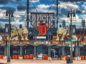 Entrance to Comerica Park with lion statues and Detroit Tigers logo.