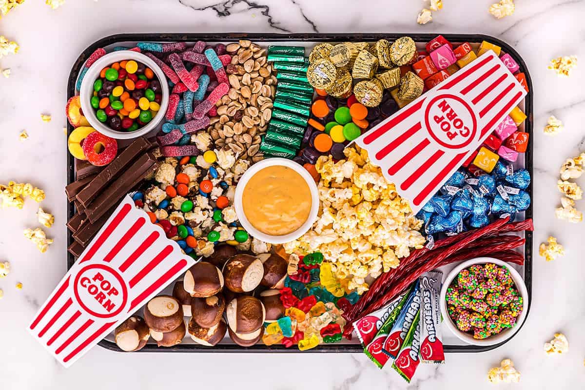 A tray of candy and popcorn on top of a table.